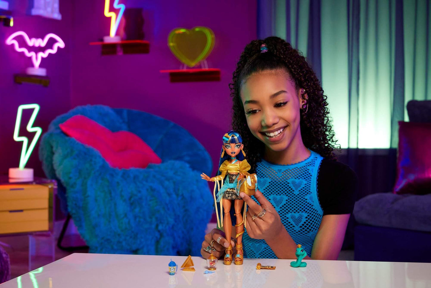 Monster High Cleo De Nile doll wearing a golden blouse and layered skirt, with pet cobra Hissette and accessories.