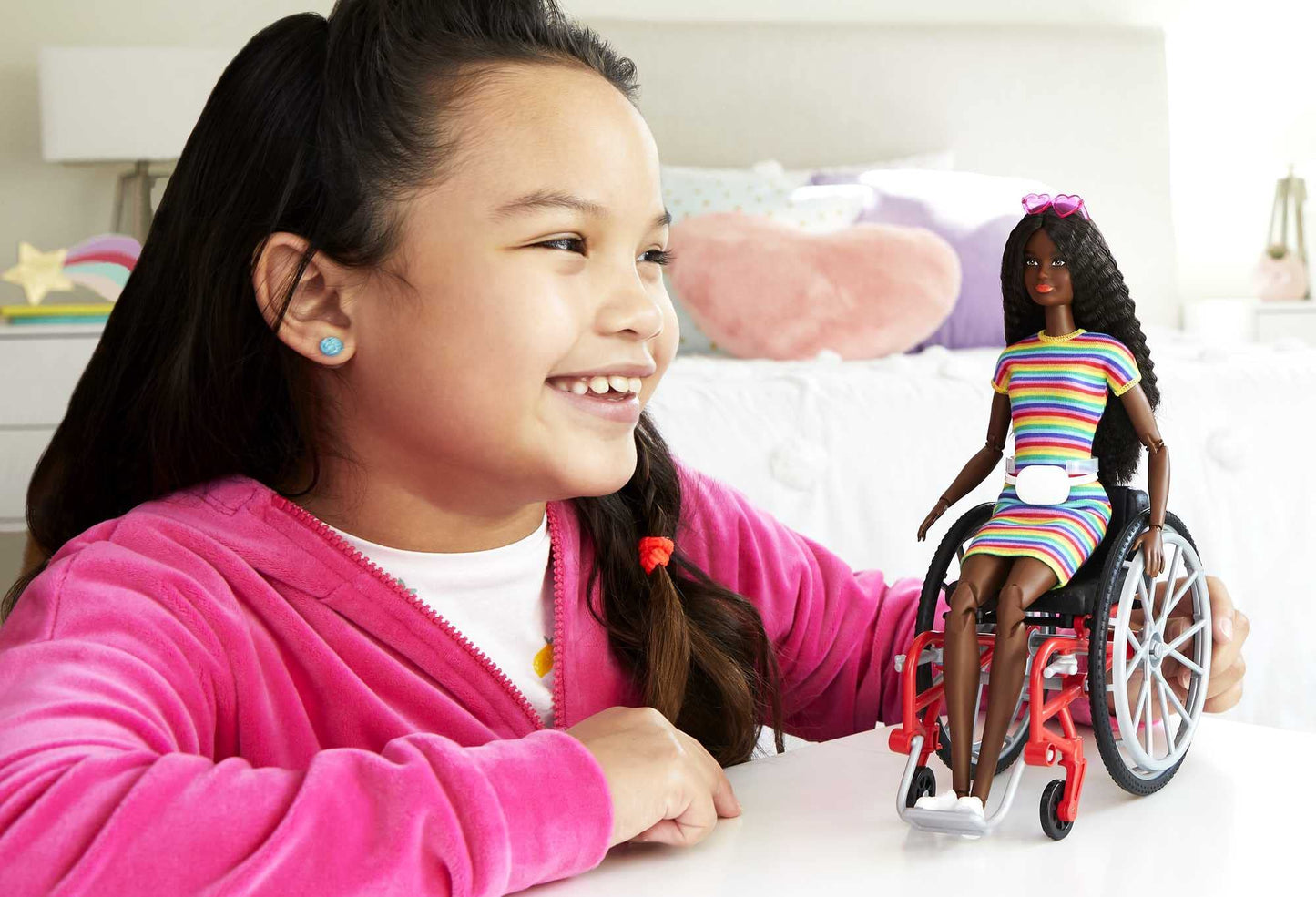Barbie Fashionistas Doll #166 with wheelchair, crimped brunette hair, rainbow dress, white sneakers, sunglasses, and fanny pack.