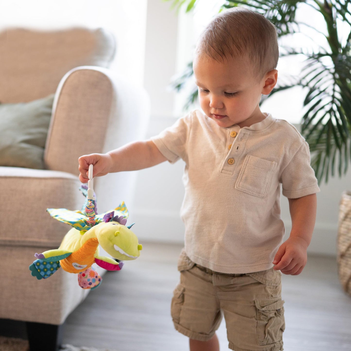 LAMAZE Flip Flap Dragon sensory baby toy attached to a pram, colorful clip-on toy for newborns from 0 to 6 months.