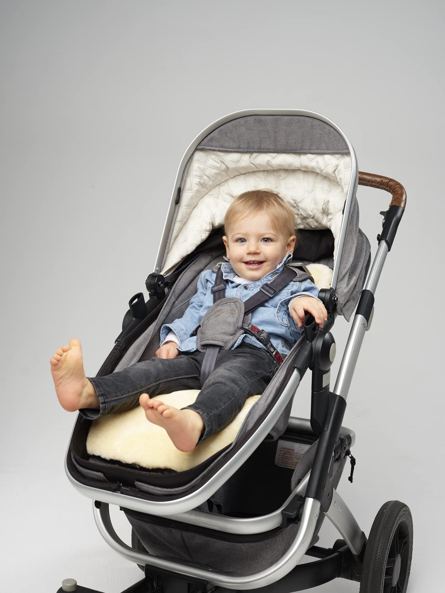 Naturally Sheepskins Merino pram liner with natural New Zealand sheepskin and cotton backing, breathable, temperature-regulating for strollers.