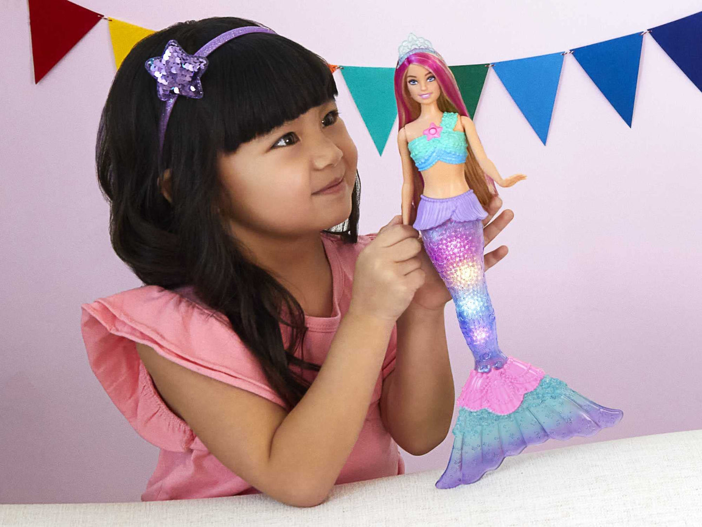 Barbie Dreamtopia mermaid doll with pink-streaked hair and light-up tail, showcasing water-activated features.