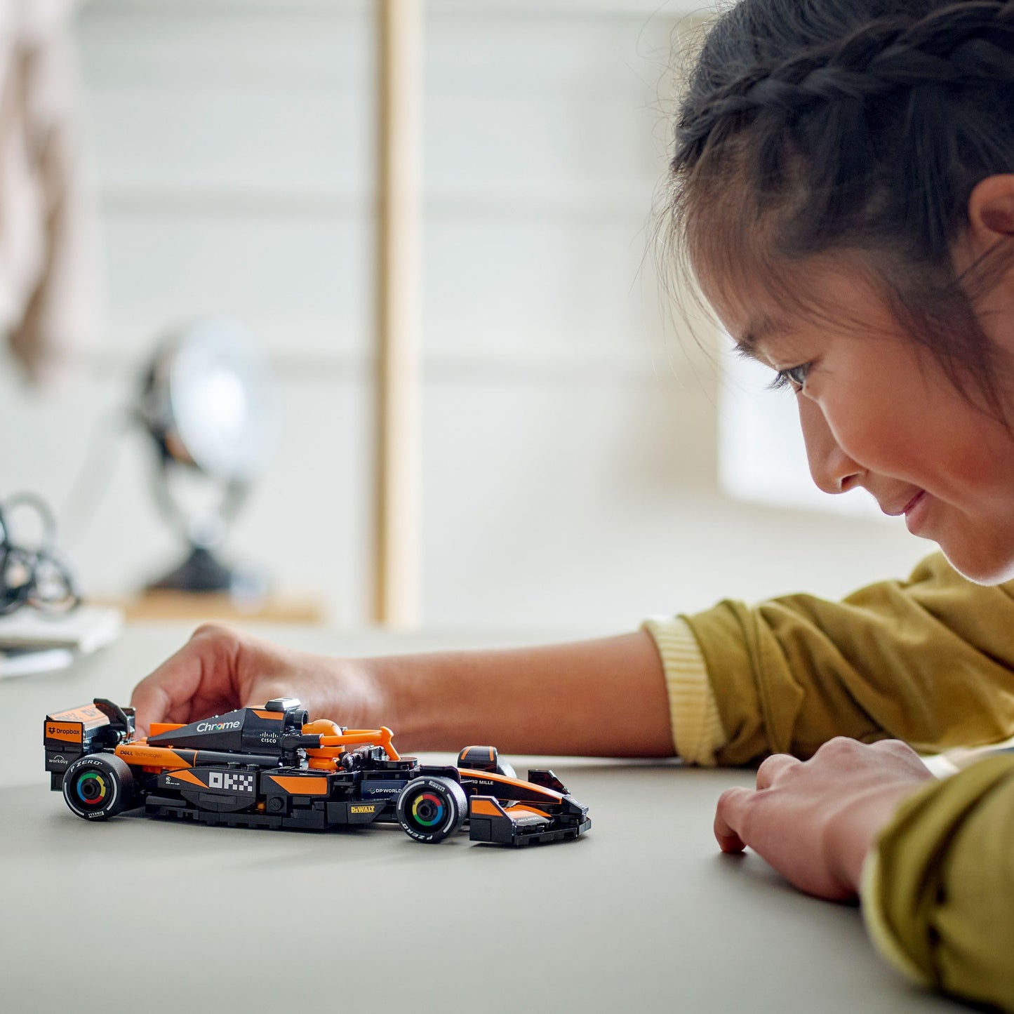 LEGO Speed Champions McLaren F1 Team MCL38 race car model kit with collectible driver minifigure on display.
