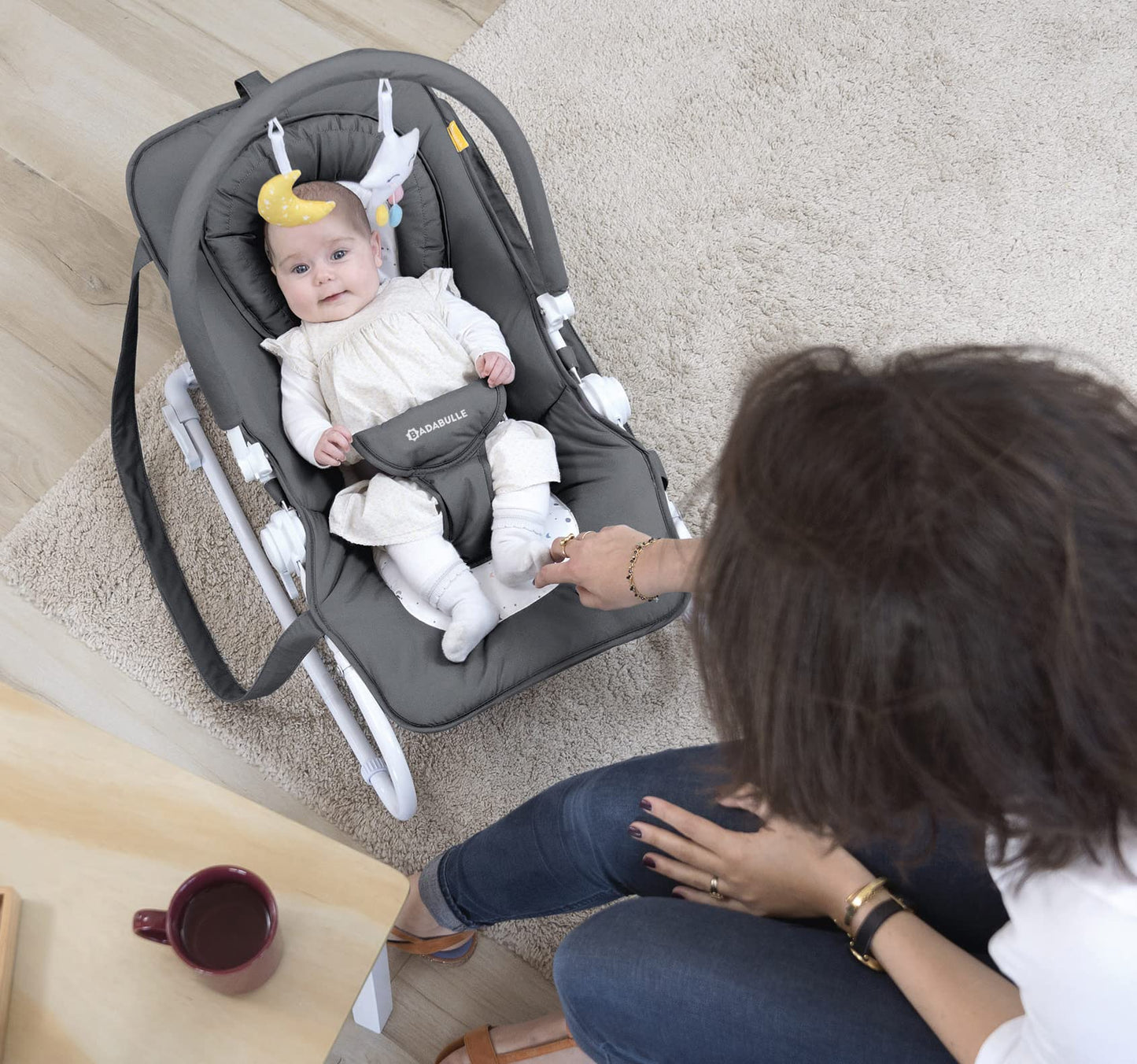Baby sitting in the Badabulle Easy Baby Bouncer, a comfortable baby chair and rocker with a padded seat and safety harness.