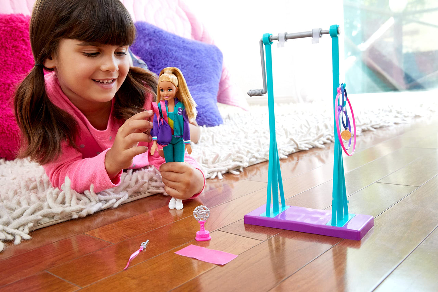 Barbie Team Stacie doll in gymnastics playset, featuring a spinning bar and seven colorful accessories.
