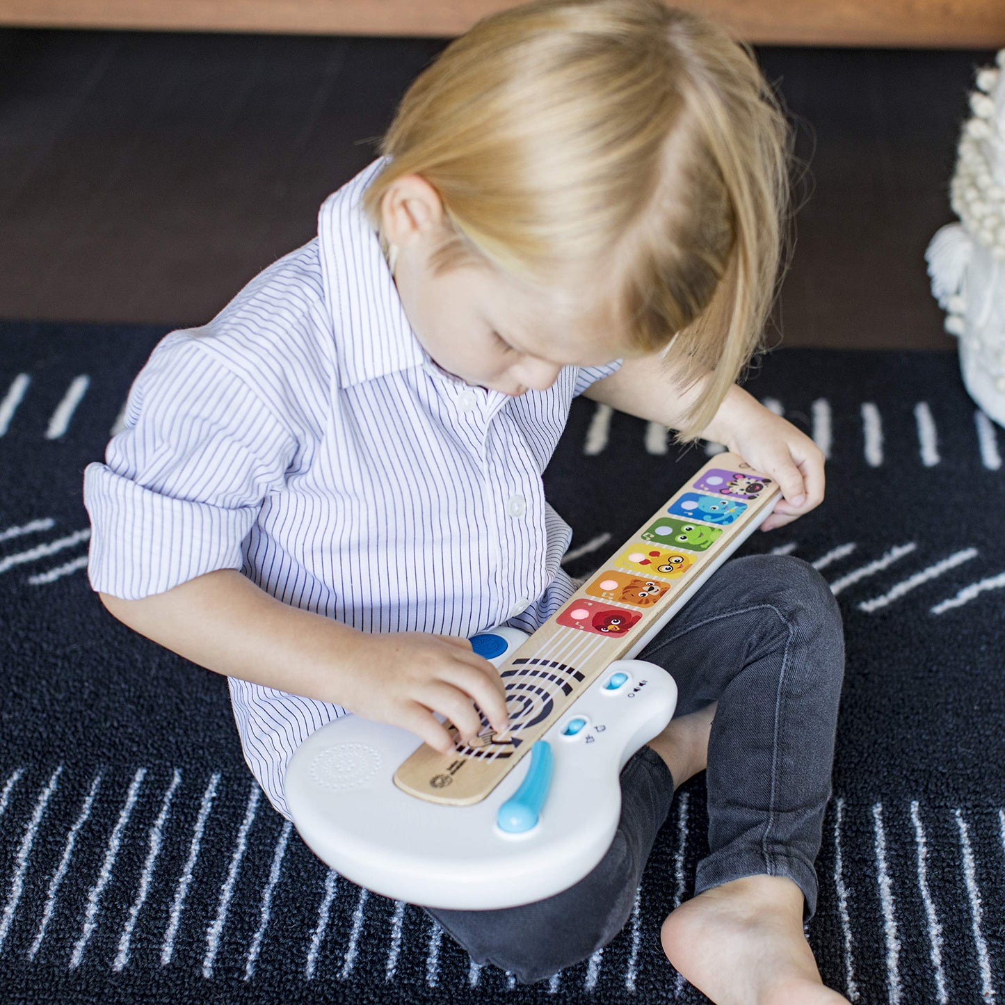 Baby Einstein Strum Along Songs magic touch wooden toy guitar with light-up buttons and whammy bar for babies 6 months and older.