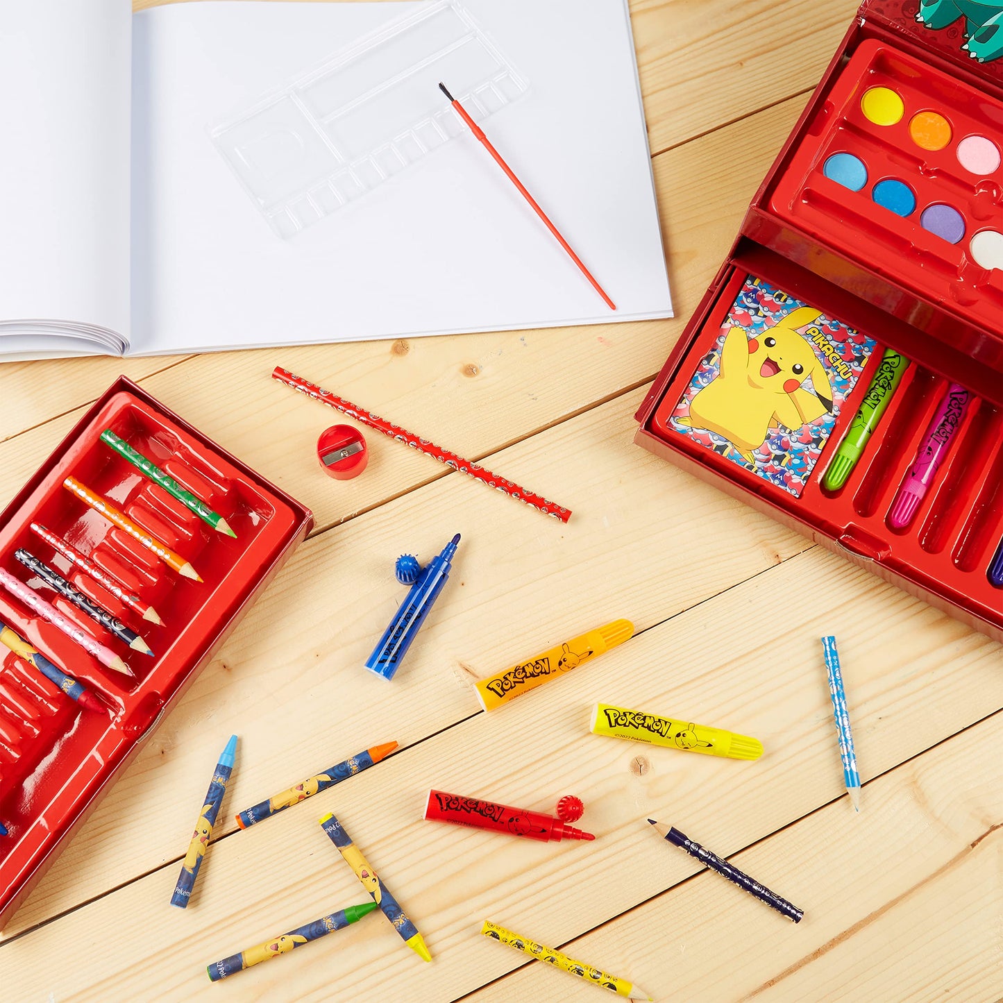 Pokemon art supplies set featuring colouring pencils, felt tip pens, watercolour paints, and crayons in black and red.