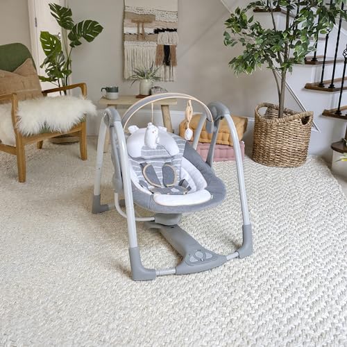 Ingenuity Swing 'n Go Deluxe baby swing with cushioned harness, plush toys, and sound features for infants 0-9 months.