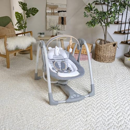 Ingenuity Swing 'n Go Deluxe baby swing with cushioned harness, plush toys, and sound features for infants 0-9 months.