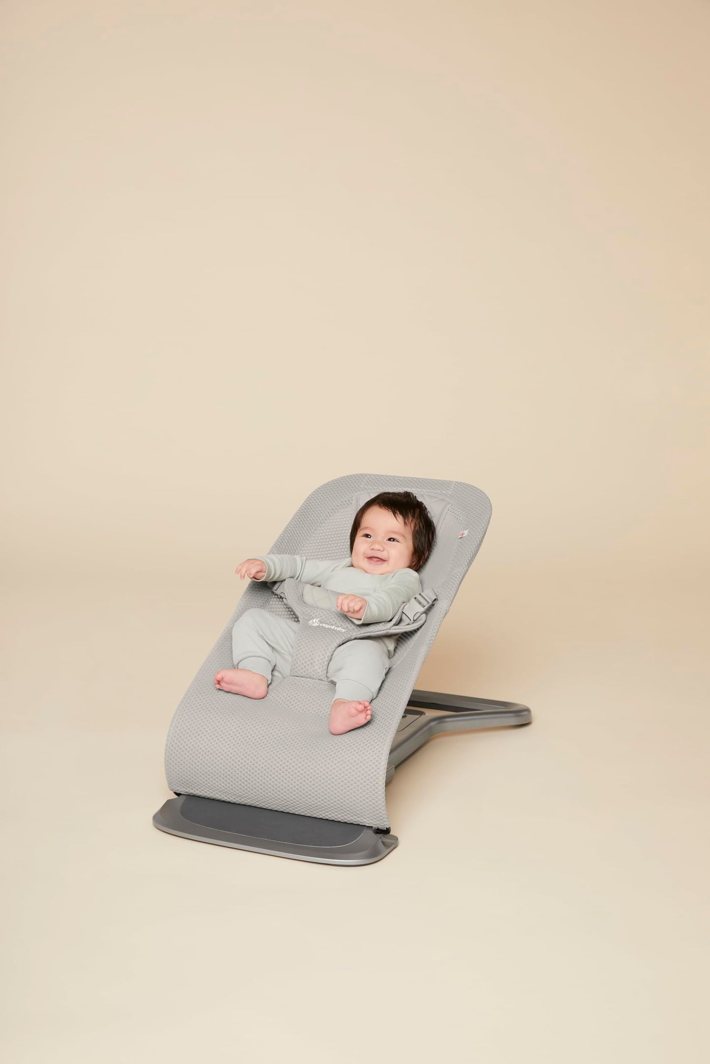 Ergobaby 3-in-1 Evolve Bouncer Mesh in light grey, ergonomic baby rocker with breathable fabric and newborn insert for infants and toddlers.