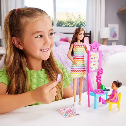 Barbie Teacher Doll with brunette hair, printed dress, toddler figure, and teaching accessories, perfect for educational play.