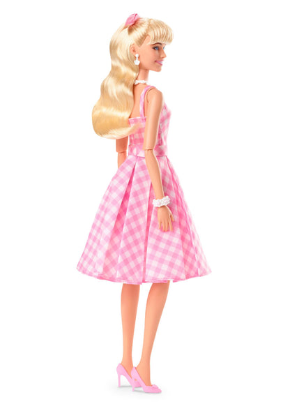 Barbie doll inspired by the movie, wearing a pink and white gingham dress and daisy chain necklace.