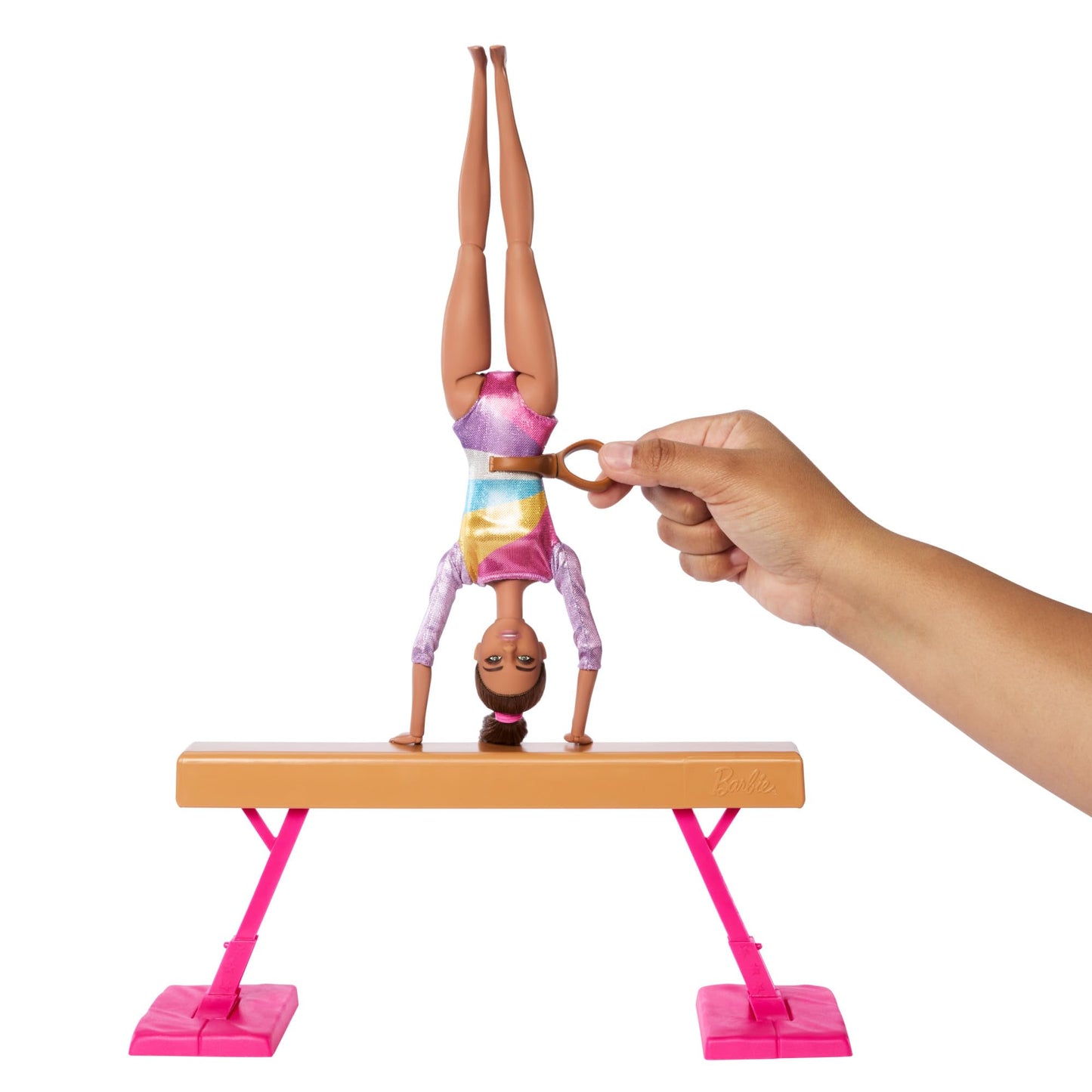 Barbie gymnastics doll playset with brunette doll, balance beam, warm-up suit, C-clip, and flipping accessories for active play.