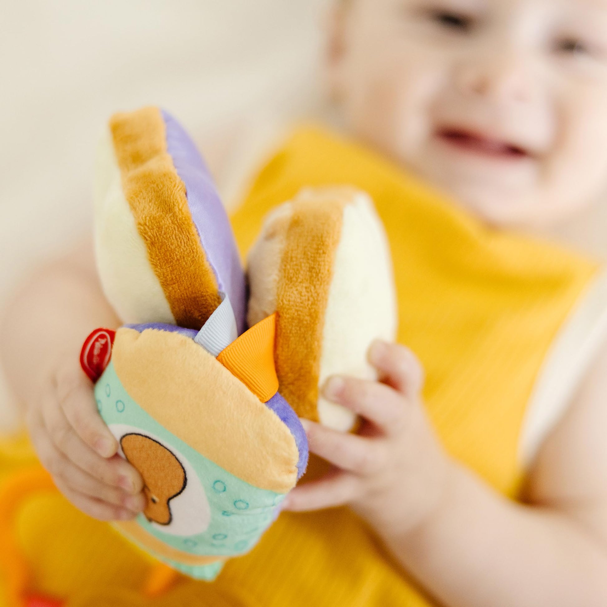 Melissa & Doug multi-sensory PB&J take-along clip-on baby toy with colorful textures and shapes for infants and toddlers.