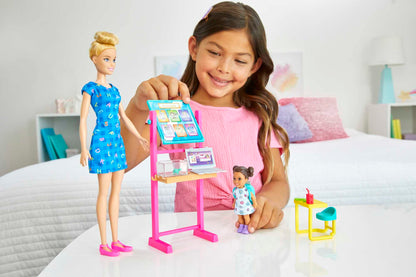 Barbie Teacher Doll with blonde hair, toddler doll with brunette hair, flip board, laptop, backpack, toddler desk, and pet turtle.