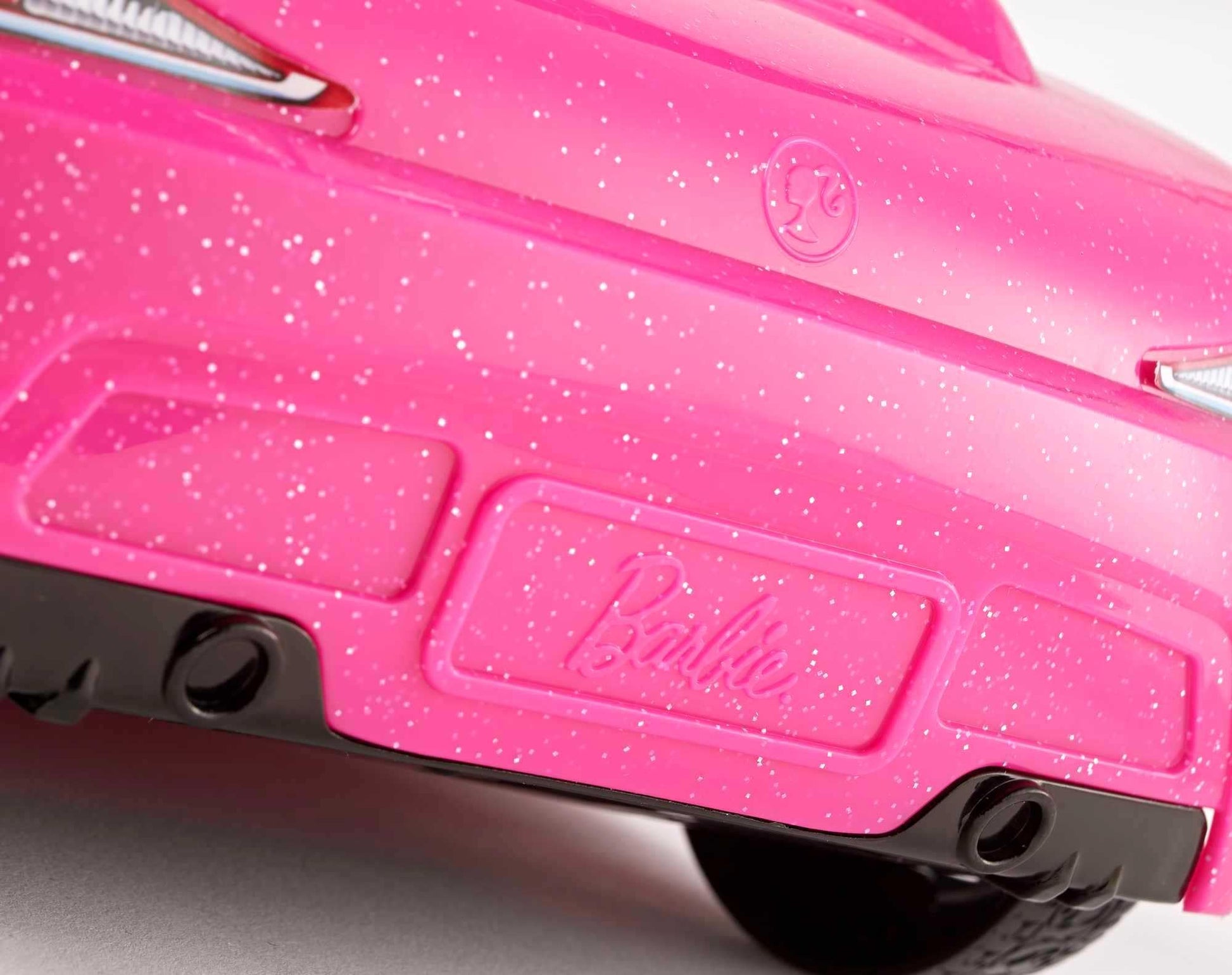 Barbie playset with sparkly pink 2-seater convertible car, fashion doll in sundress and sunglasses, featuring glam details.