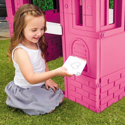 Pink Little Tikes Cape Cottage princess playhouse with working doors, windows, and shutters for kids' imaginative outdoor play.