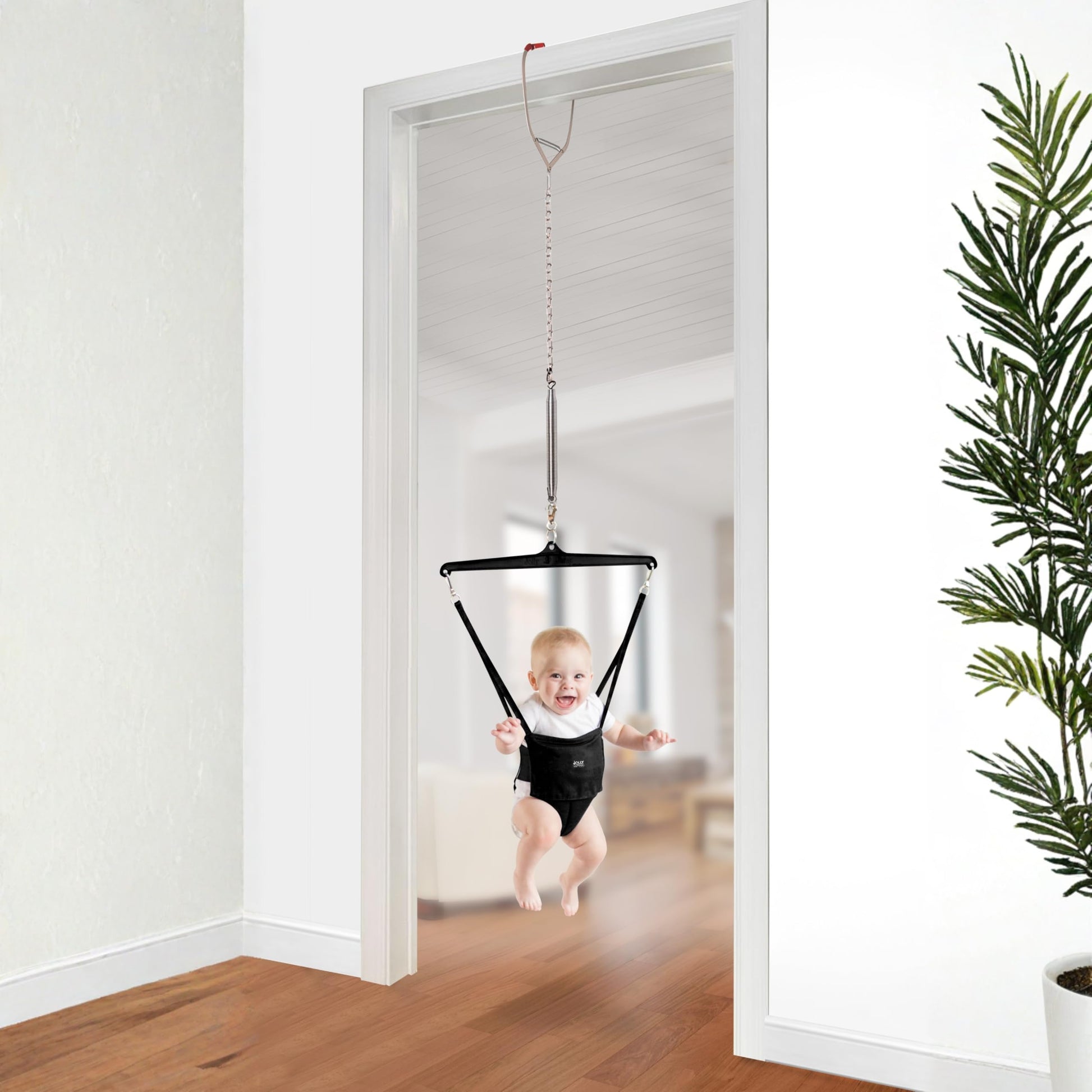 Baby in The Original Jolly Jumper Baby Exerciser with door clamp, showing the jumper seat and adjustable door attachment.
