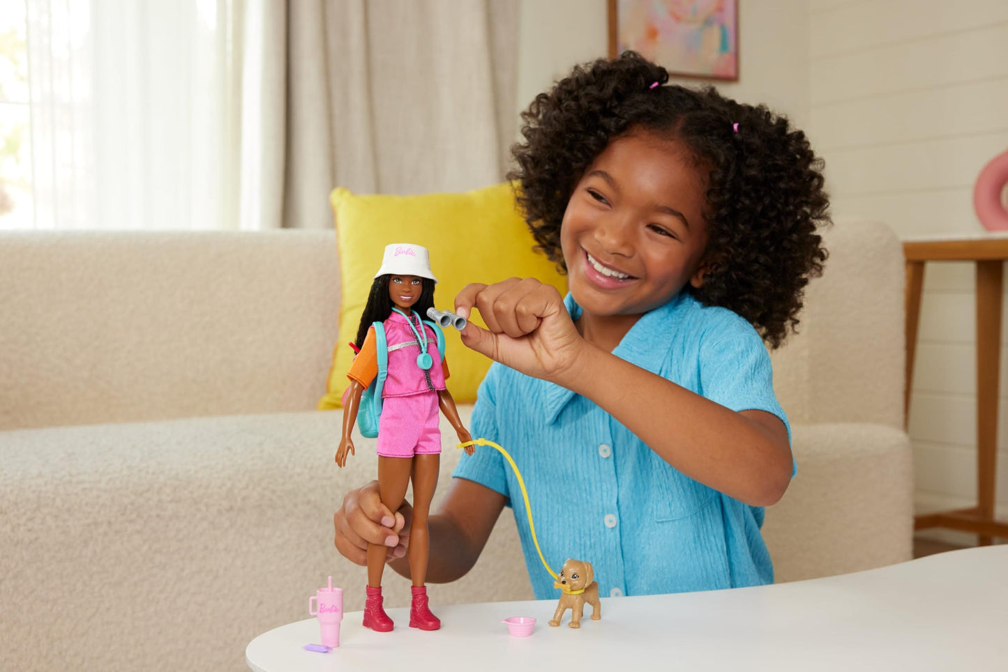 Barbie Brooklyn doll in adventure outfit with camping accessories and a pet puppy, ready for outdoor fun.