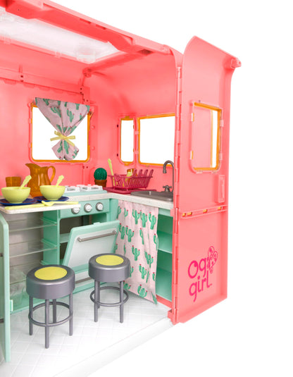 Our Generation pink camping trailer with kitchen accessories for 18-inch dolls, ideal for pretend play.