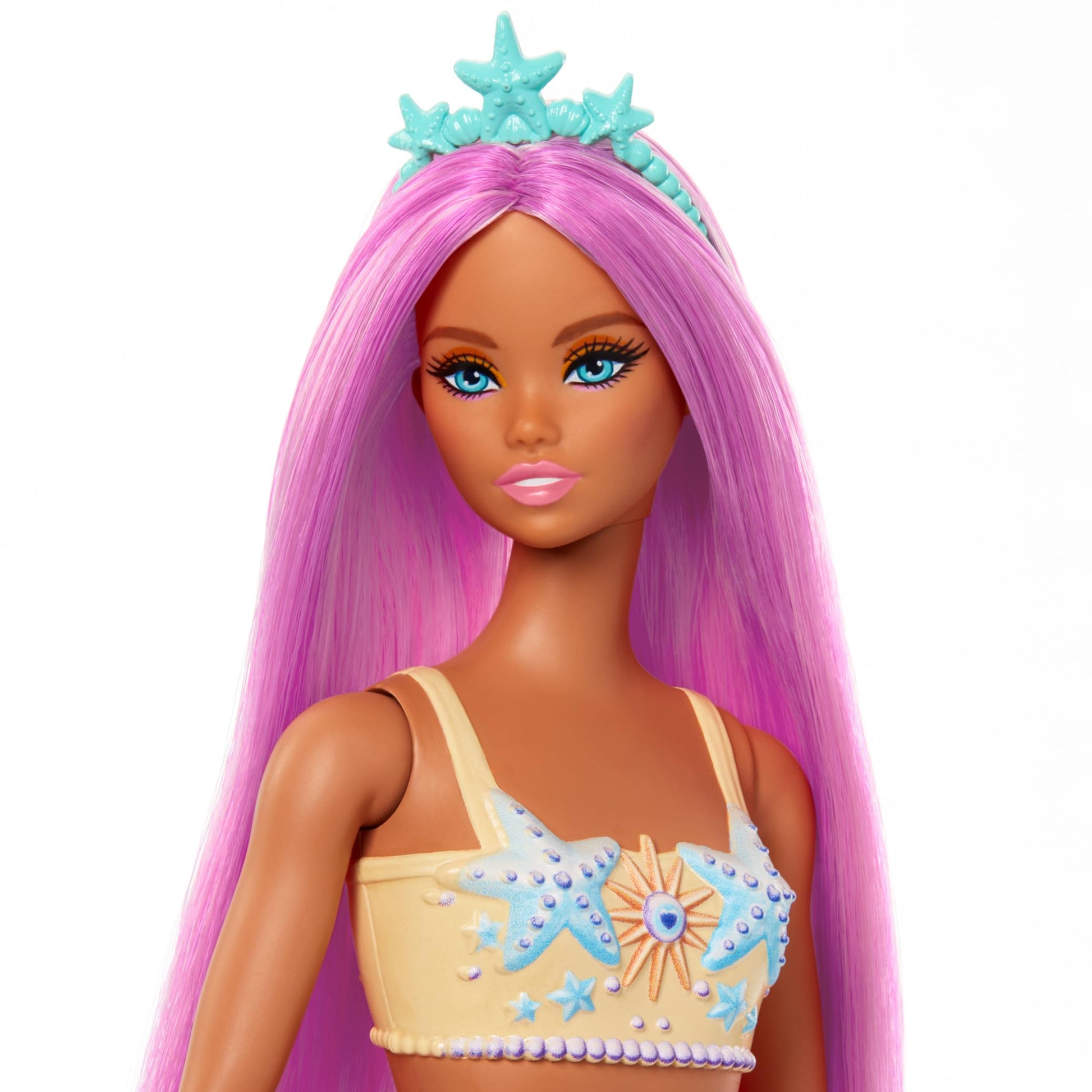 Barbie mermaid doll with pink hair, starfish bodice, and soft orange tail, wearing a headband accessory.