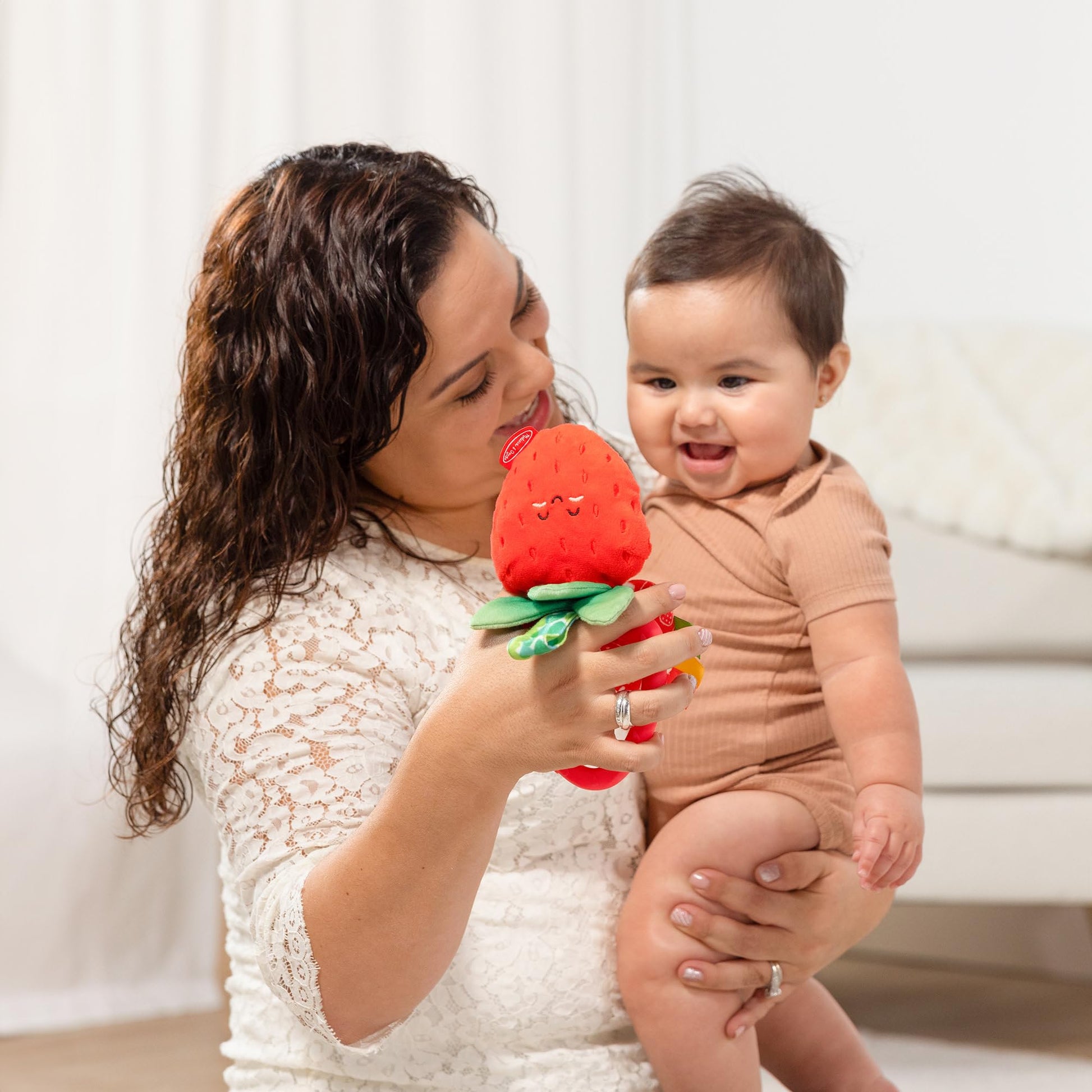 Melissa & Doug multi-sensory peek-a-boo berry clip-on infant travel toy with colorful textured features for babies up to 12 months.