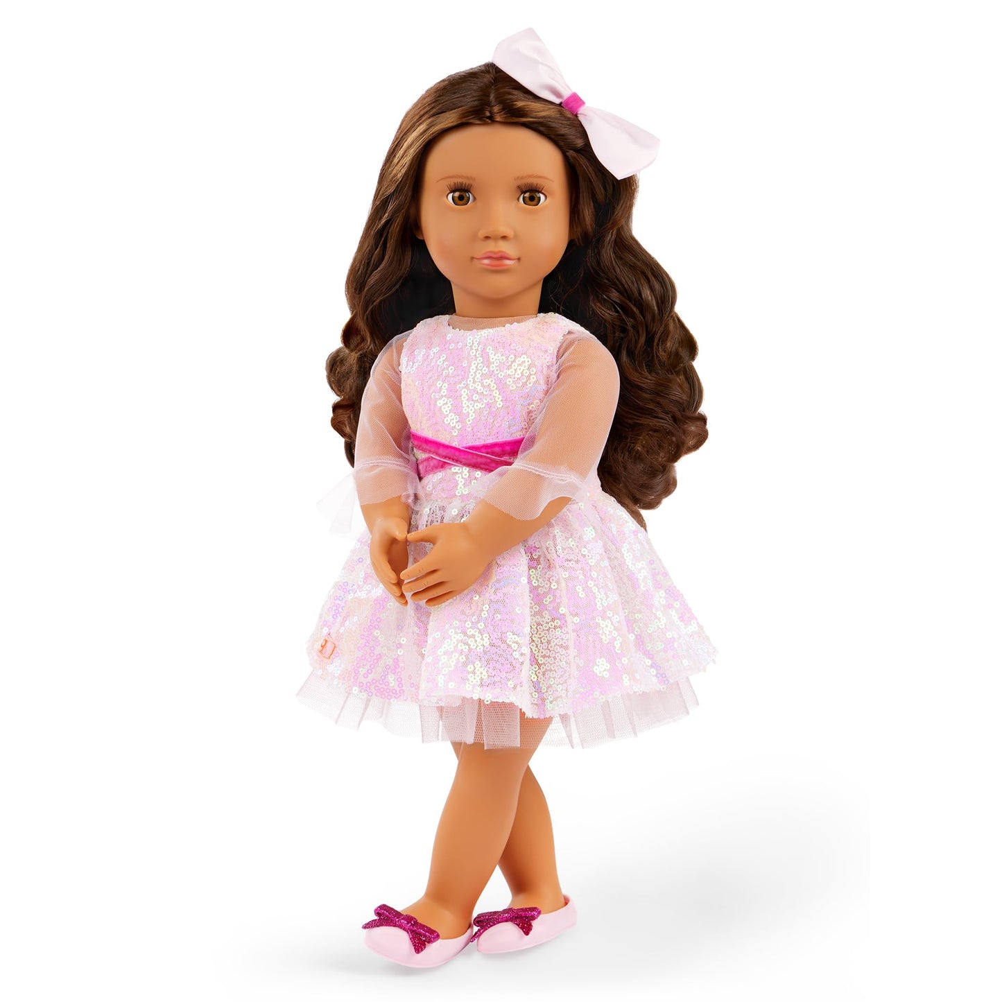 Our Generation doll Katia with long brown hair, wearing a pink dress and white shoes, posed against a colorful background.