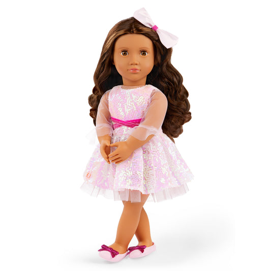 Our Generation doll Katia with long brown hair, wearing a pink dress and white shoes, posed against a colorful background.