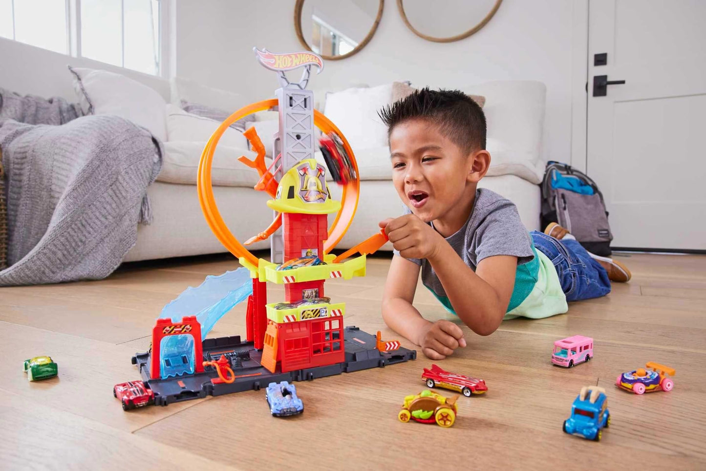 Hot Wheels City set featuring a toy car, kid-powered elevator, fire station, and water-like ramp for track play.