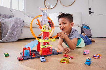 Hot Wheels City set featuring a toy car, kid-powered elevator, fire station, and water-like ramp for track play.