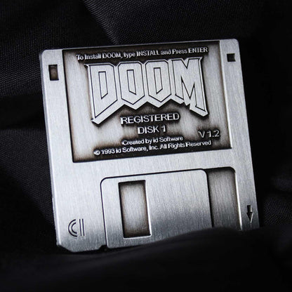 Metal DOOM floppy disk pin badge by FaNaTtik, collectible gaming merchandise featuring official licensed design for fans and collectors.