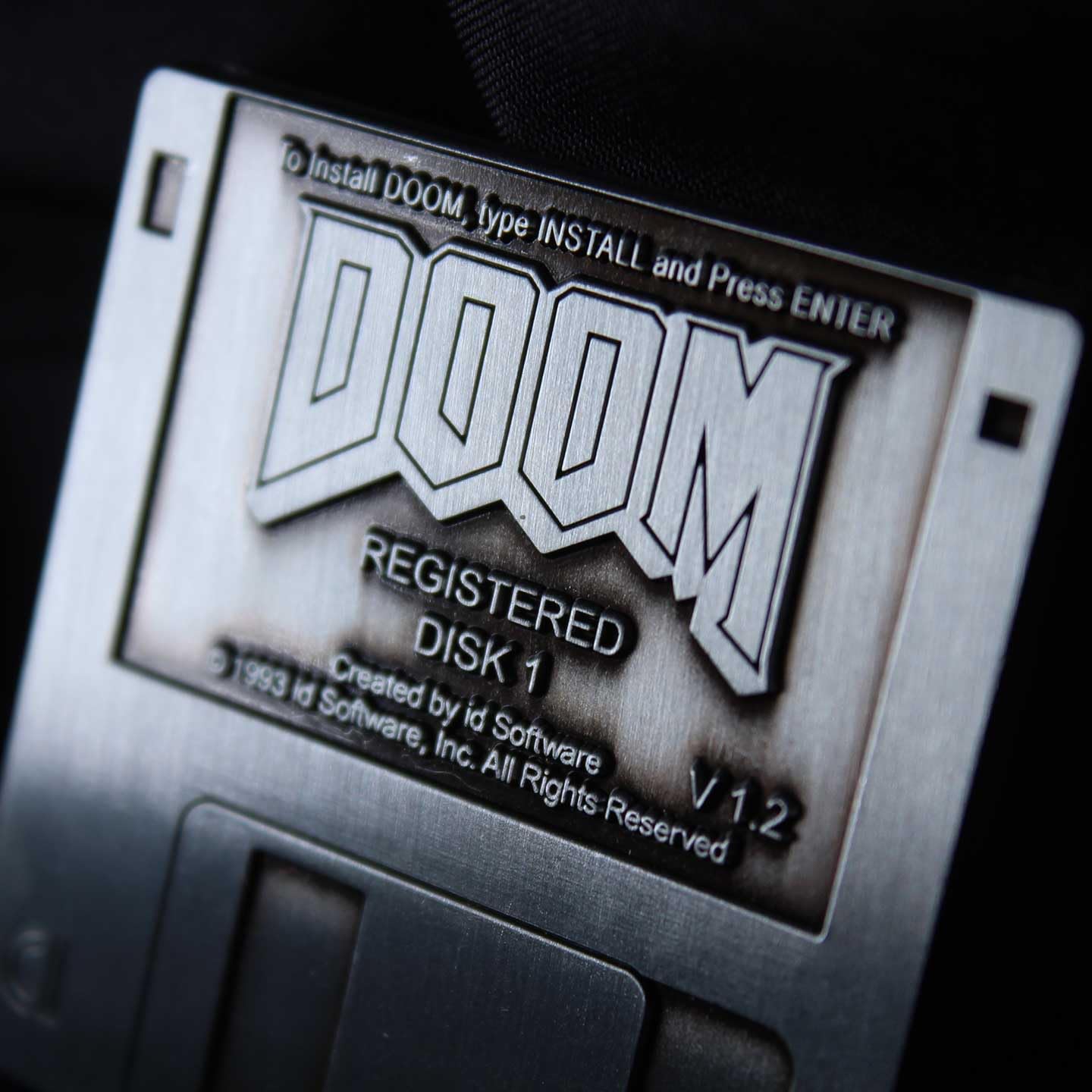 Limited edition DOOM floppy disk pin badge by FaNaTtik, a collectible metal gaming accessory for fans and collectors.
