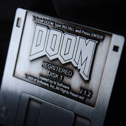 Limited edition DOOM floppy disk pin badge by FaNaTtik, a collectible metal gaming accessory for fans and collectors.