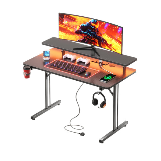 CAIYUN small gaming desk with LED lighting, power outlets, full monitor stand, black carbon fiber surface, and metal frame.