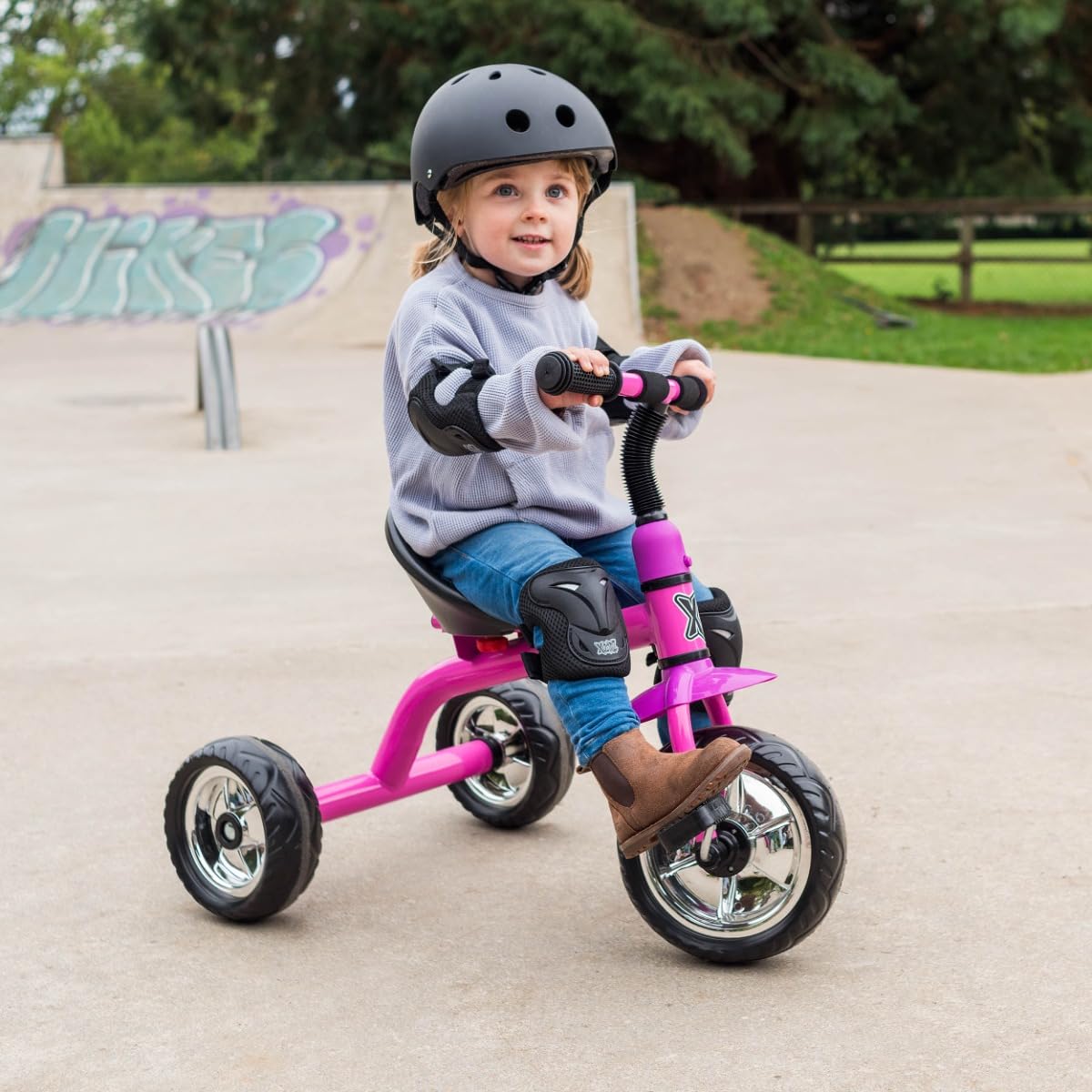 Pink Xootz tricycle for kids, featuring easy clip design and portable construction, ideal for outdoor fun.