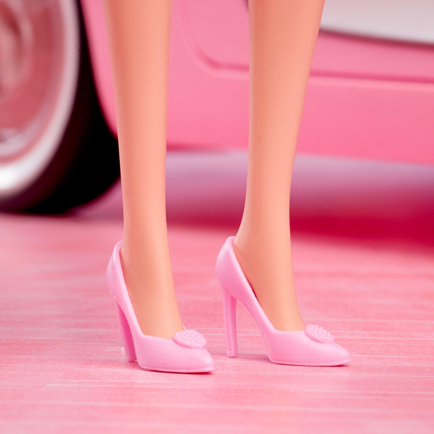 Barbie collectible doll of Margot Robbie in pink blouse and tutu skirt, styled hair, and matching jewelry.