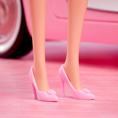 Barbie collectible doll of Margot Robbie in pink blouse and tutu skirt, styled hair, and matching jewelry.