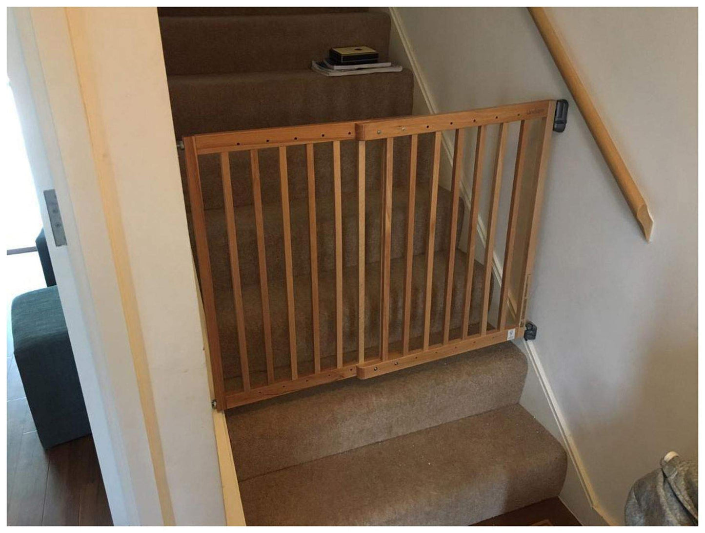 Munchkin Lindam Wall Fix extending wooden safety gate installed in doorway, with secure wall mounts and adjustable width for child safety.