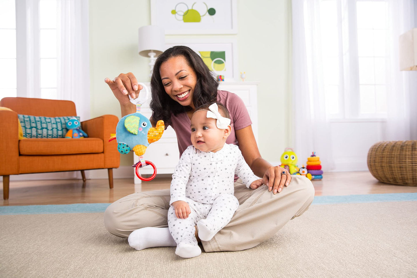 LAMAZE Mini Eloy the Elephant baby toy clipped to a pram, sensory toy for newborns 0-6 months, soft fabric, colorful design.
