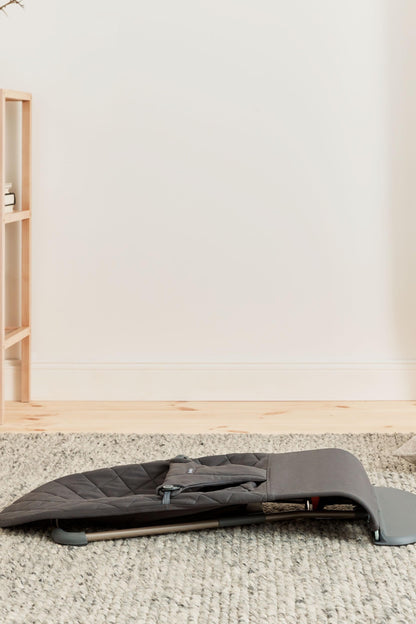 BabyBjörn Bouncer Bliss woven classic quilt in anthracite, showing the comfortable baby bouncer with fabric and frame in a cozy setting.