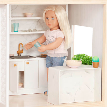 Our Generation dollhouse playset featuring movable furniture pieces for bedroom, kitchen, and bathroom in a cozy setup.
