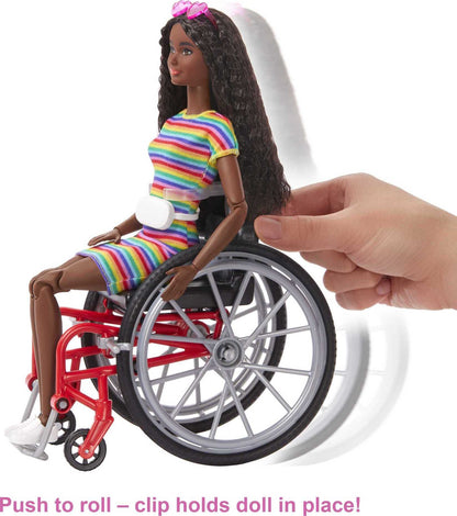 Barbie Fashionistas Doll #166 with wheelchair, crimped brunette hair in rainbow-striped dress, white sneakers, sunglasses, and fanny pack.
