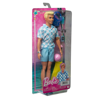 Barbie Blonde Ken doll wearing a blue button-down shirt and swim trunks, with beach accessories including a visor and towel.