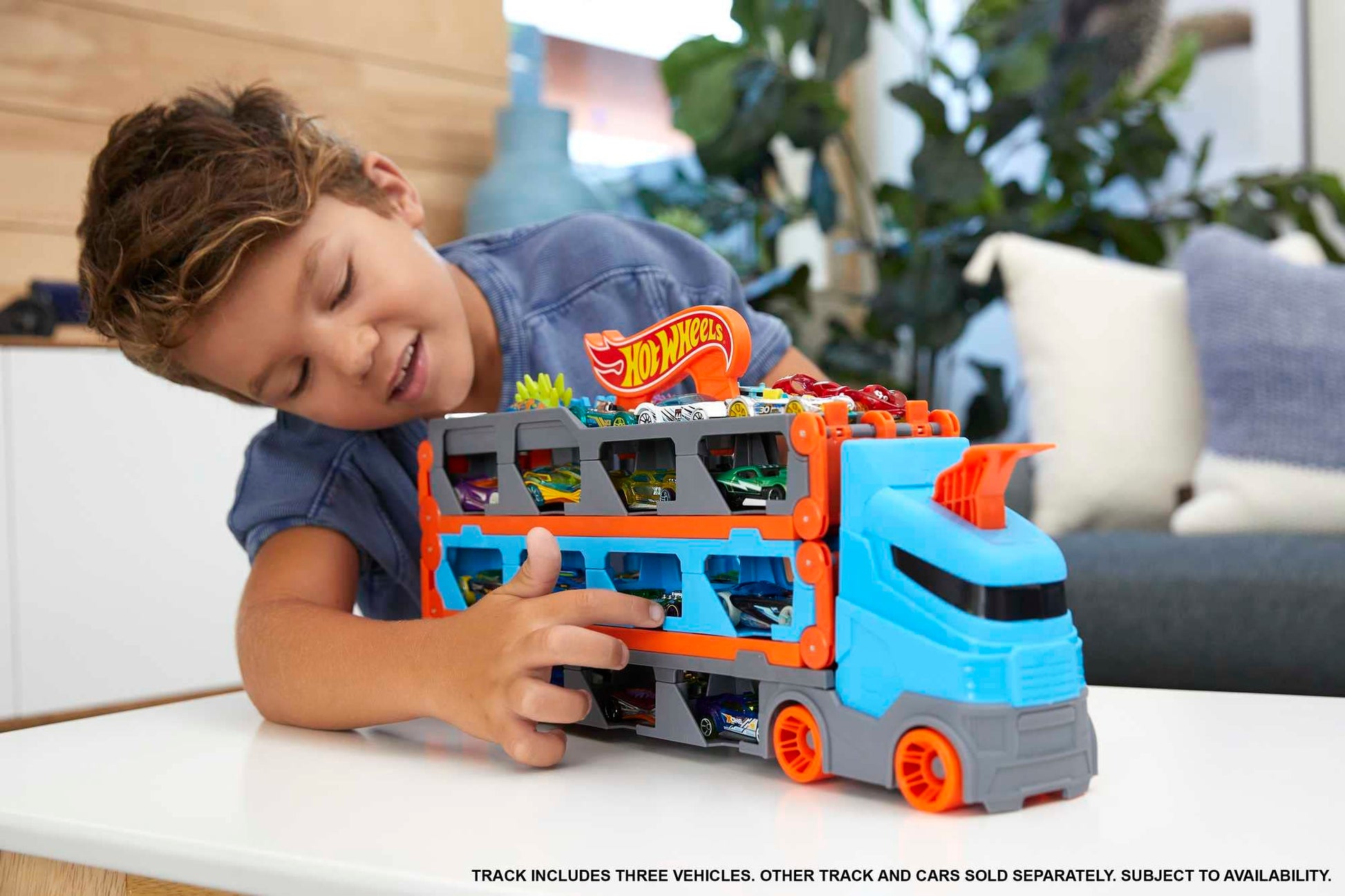 Hot Wheels Speedway Hauler Carrier with 3 cars and 6-foot drag race track for kids, featuring storage for 20+ cars.