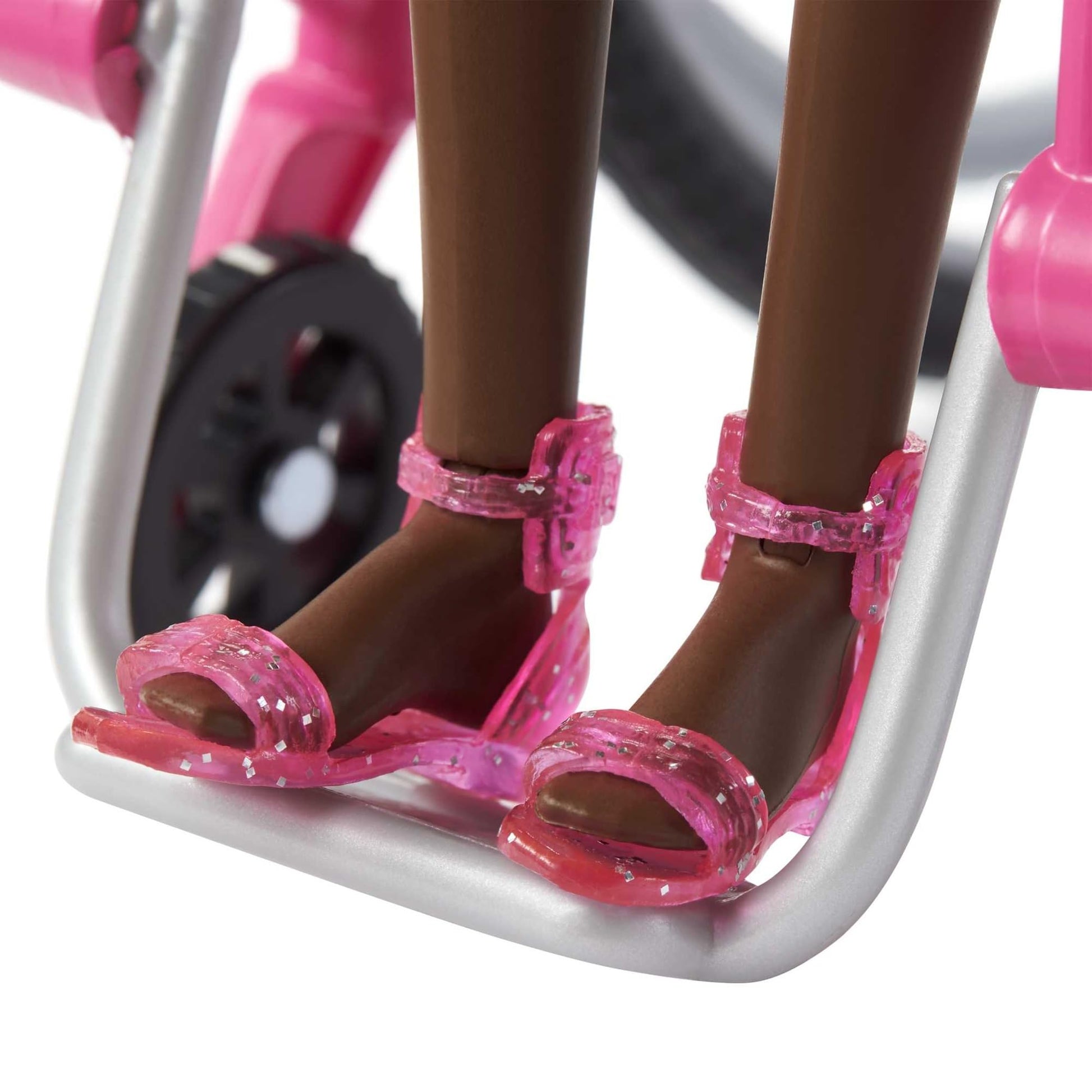 Barbie Fashionistas doll in a rainbow heart romper, with a wheelchair and ramp, featuring curly black hair and accessories.