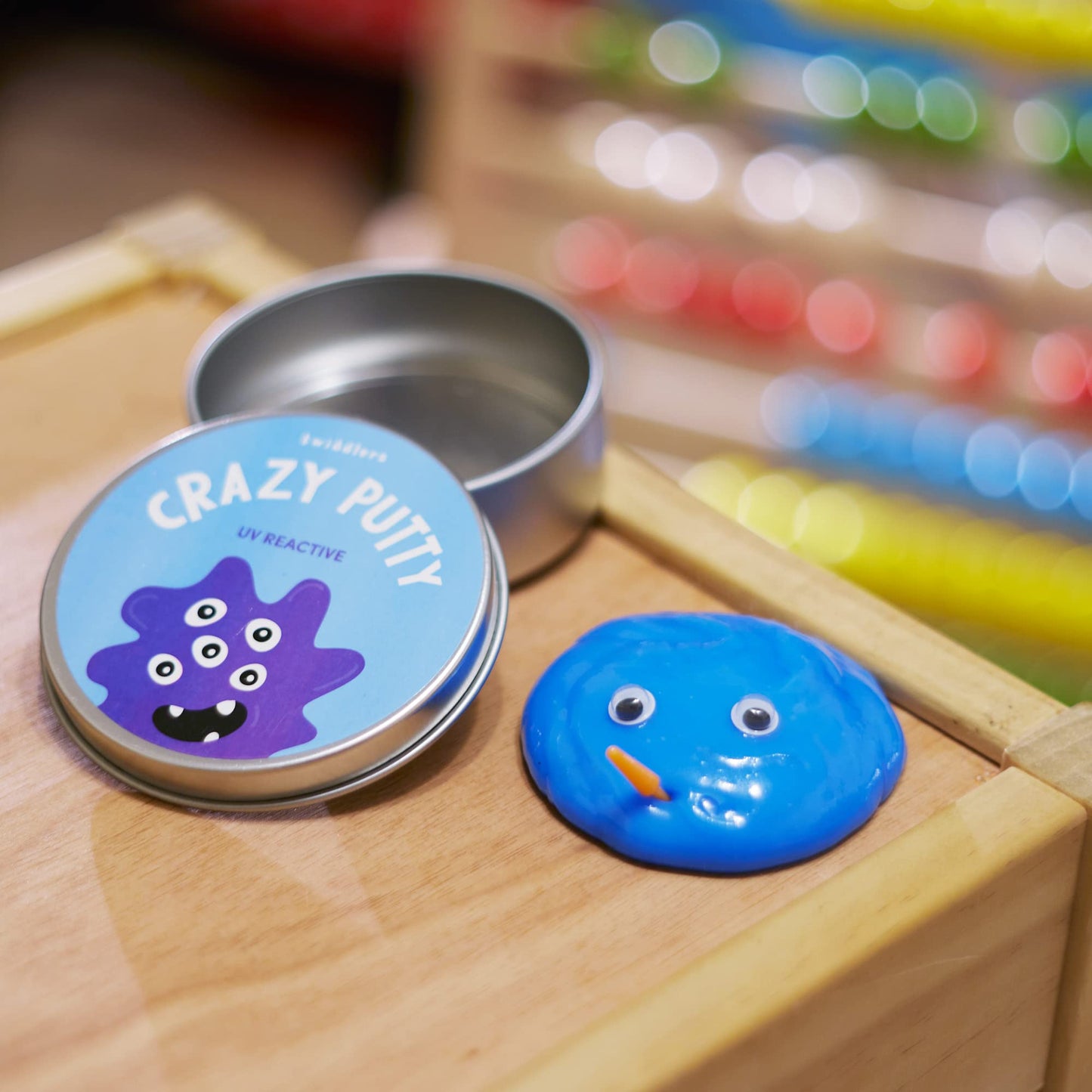 Color-changing putty in lid pots with mini UV torches, sensory slime toy by THE TWIDDLERS, perfect for kids' DIY art and calming activities.