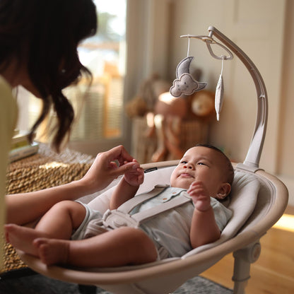 Maxi-Cosi Cassia electric baby swing chair in classic beige with 360° seat rotation, 12 melodies, and adjustable recline for infants.