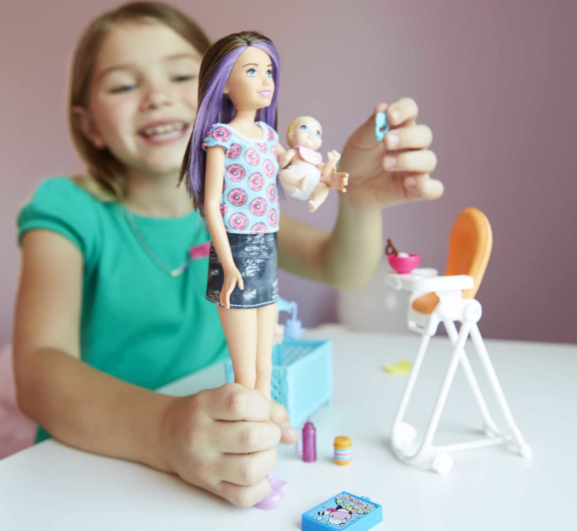 Barbie FHY98 family babysitter brunette doll with baby, highchair playset, and colorful accessories.