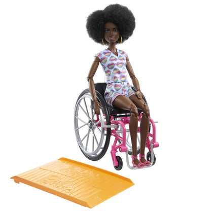 Barbie Fashionistas doll with curly black hair in rainbow heart romper, seated in wheelchair with ramp and accessories.