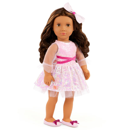 Our Generation doll Katia with brown hair wearing a stylish outfit, seated in a colorful playroom setting.