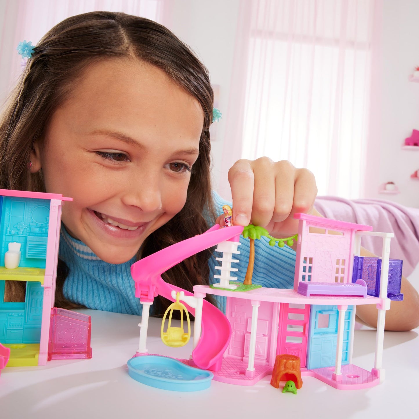 Mini BarbieLand dollhouse set with furniture, elevator, and pool, includes 1.5-inch Barbie doll, for ages 4 and up.